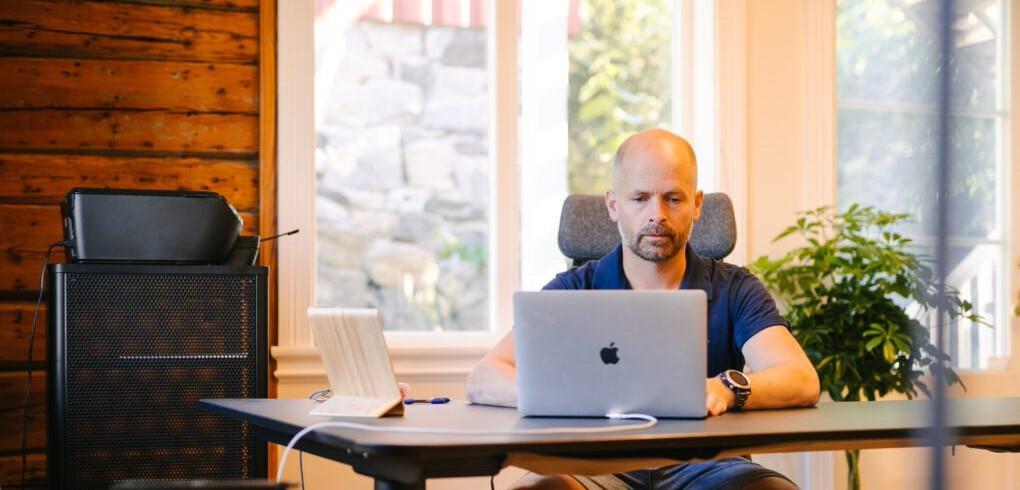 bilde av kontorom, man bak arbeidspult - Klikk for stort bilde